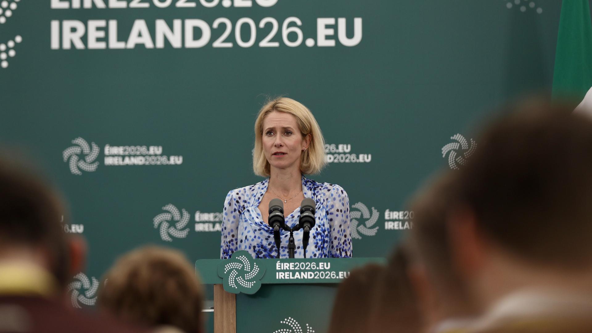 Kaja Kallas steht an einem Rednerpult vor zwei Mikrofonen. Kaja Kallas steht an einem Rednerpult vor zwei Mikrofonen.