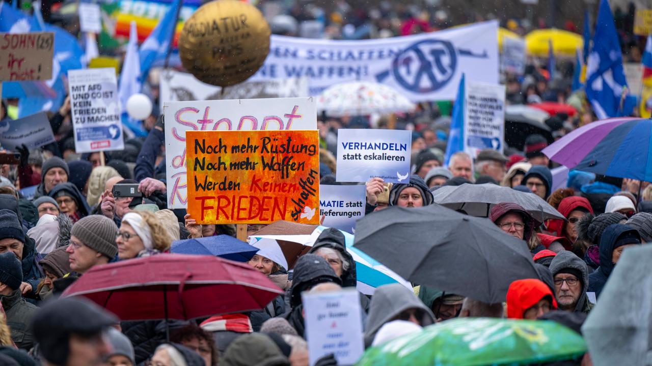 Zahlreiche Teilnehmer der Demonstration halten Schilder und Transparente in die Höhe. Am Brandenburger Tor in Berlin haben sich mehrere Tausend Menschen zu einer Kundgebung für Verhandlungen mit Russland im Ukraine-Krieg versammelt.