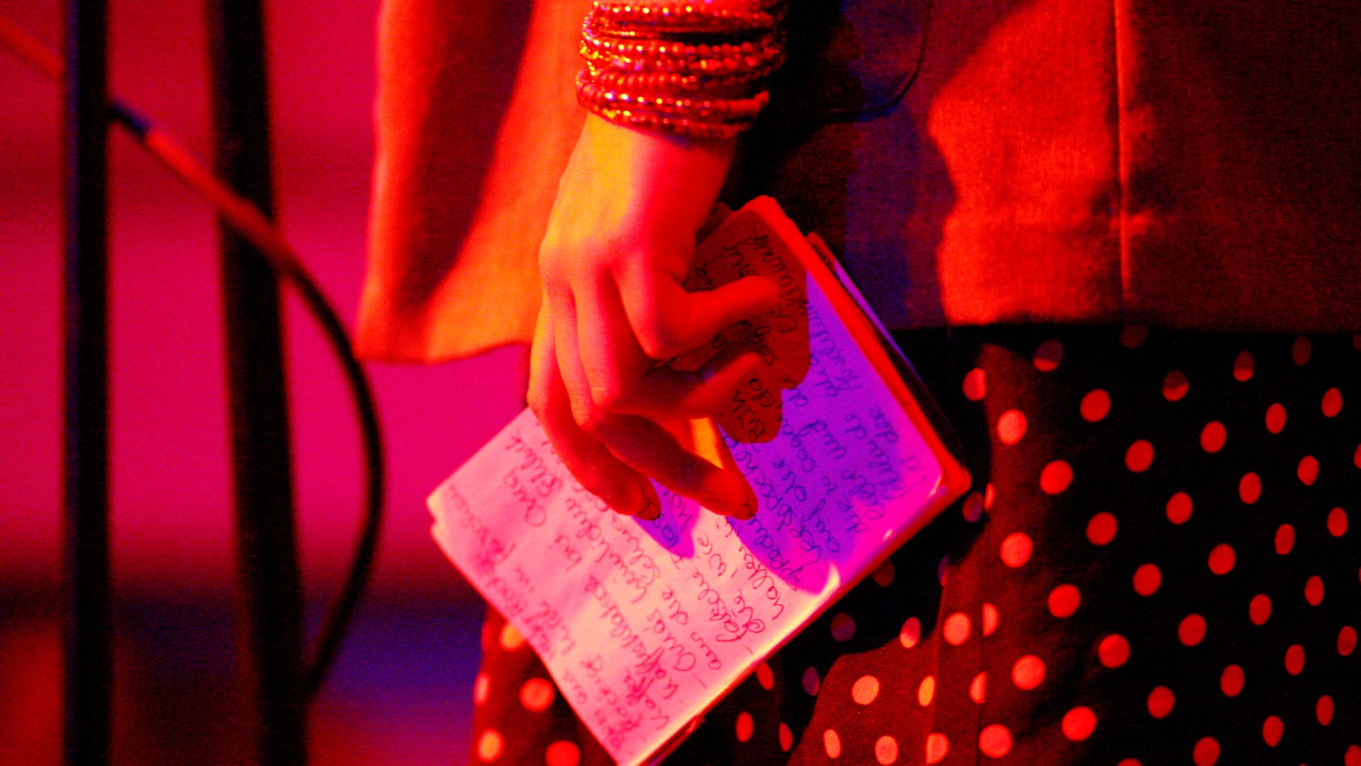 Eine Autorin hält ihre Notizen in der Hand. 