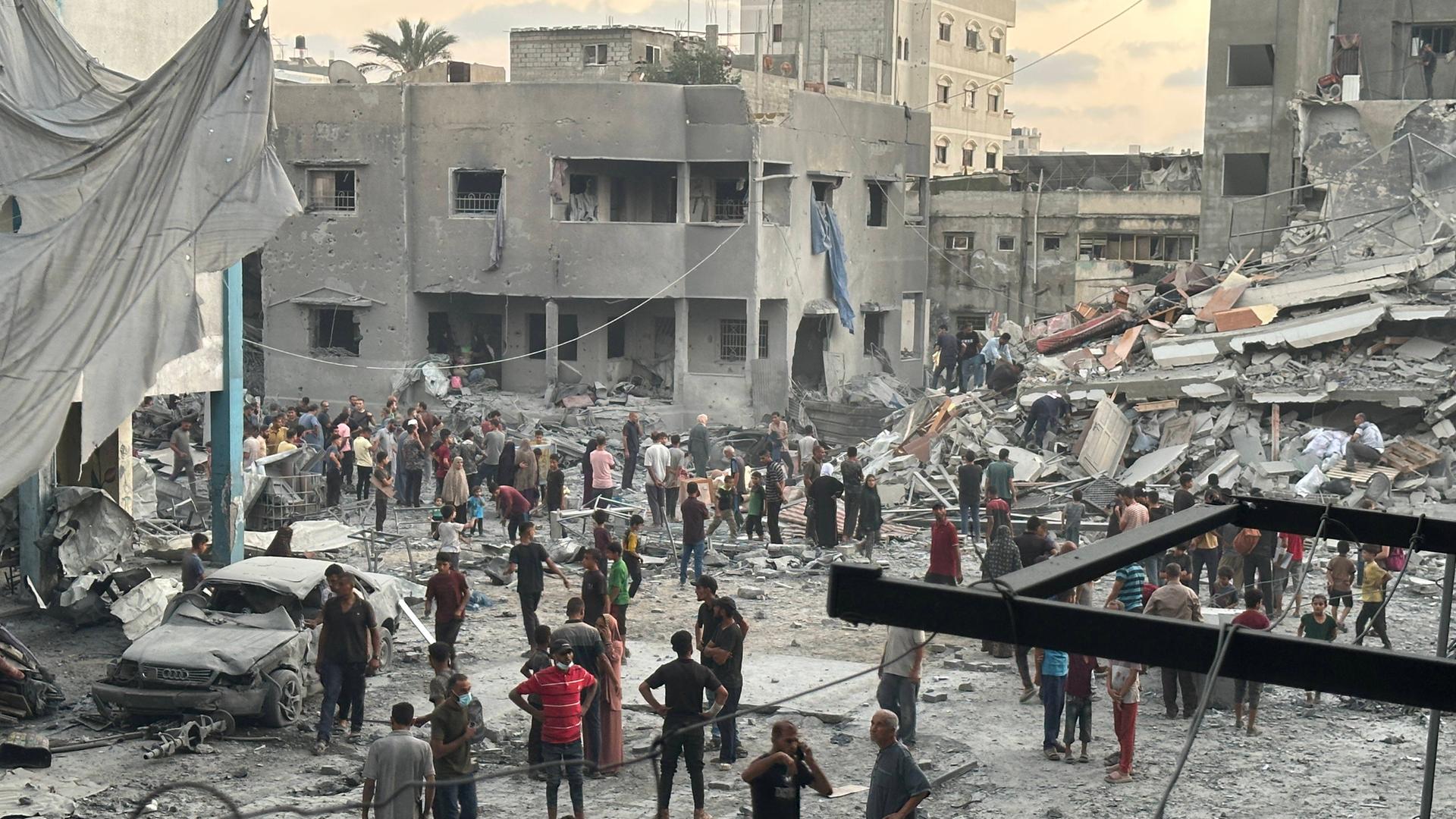 Menschen versammeln sich vor einem Gebäude, das bei einem israelischen Luftangriff westlich von Gaza-Stadt beschädigt wurde. Menschen versammeln sich vor einem Gebäude, das bei einem israelischen Luftangriff westlich von Gaza-Stadt beschädigt wurde.