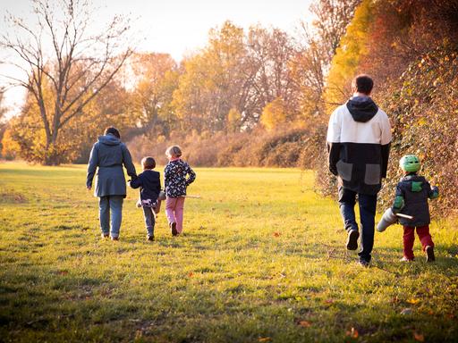Familie beim Herbstspaziergang von hinten fotografiert