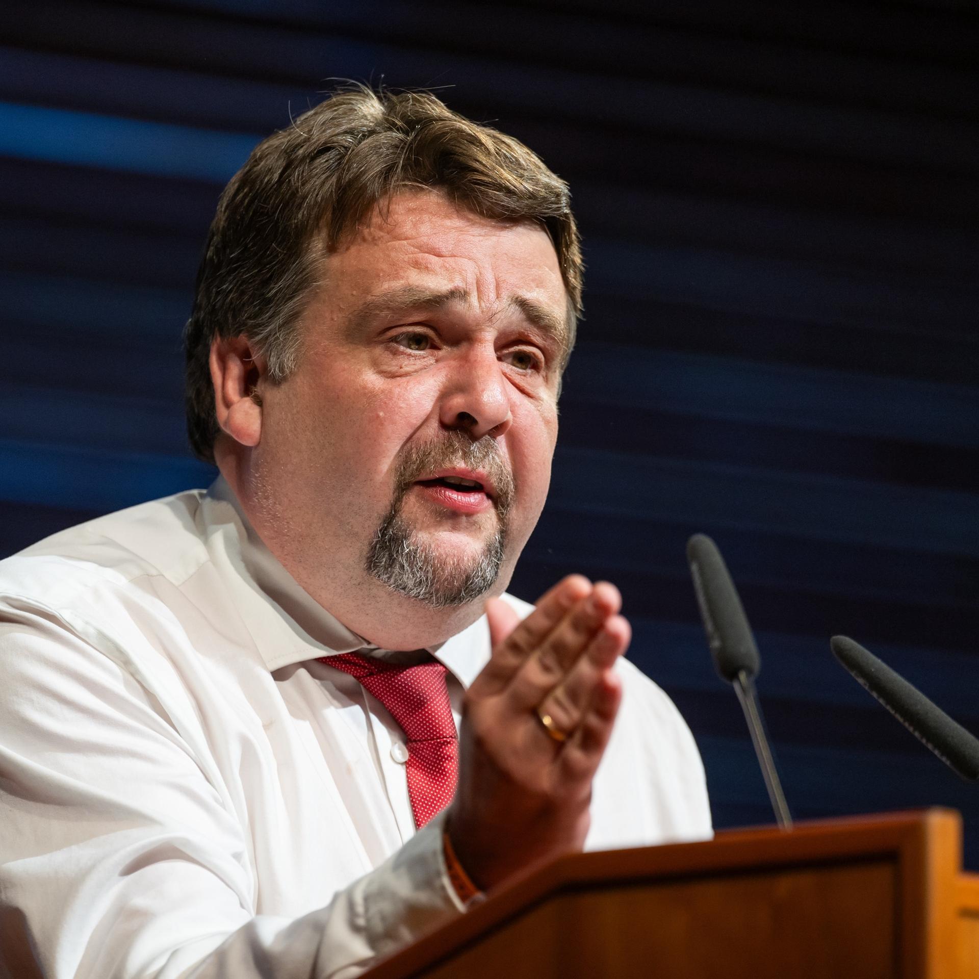 Dennis Radtke steht hinter einem Rednerpult und gestikuliert mit der rechten Hand.