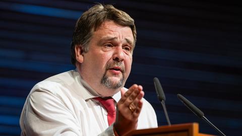 Dennis Radtke steht hinter einem Rednerpult und gestikuliert mit der rechten Hand.
