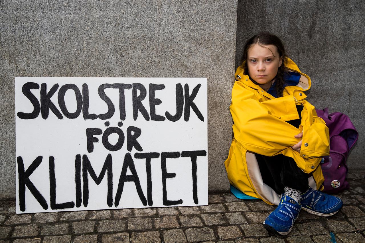 Die fünfzehnjährige schwedische Schülerin Greta Thunberg bei Ihrem Schulstreik am 28. August 2018. Sie sitzt in eingehüllt in einem gelben Frisennerz vor dem Riksdagen, dem schwedischen Parlamentsgebäude, um das Bewusstsein für den Klimawandel zu schärfen.