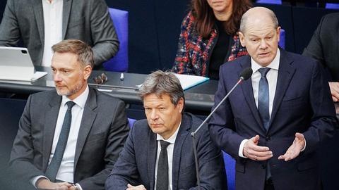 Bundeskanzler Olaf Scholz (SPD, r) spricht im Bundestag bei der Befragung der Bundesregierung neben Christian Lindner (FDP, l), Bundesminister der Finanzen, und Robert Habeck (Bündnis 90/Die Grünen, M), Bundesminister für Wirtschaft und Klimaschutz, zu den Abgeordneten im Plenum.