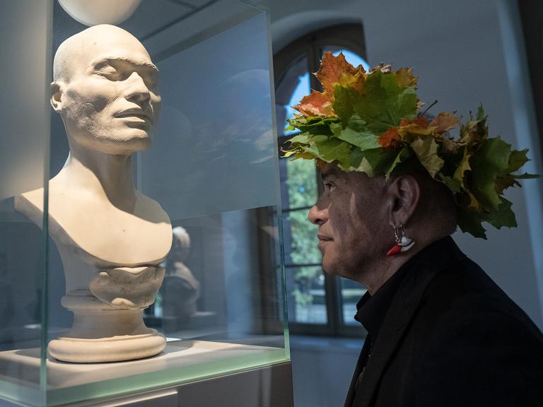 Te Herekiekie Herewini vom Museum of New Zealand Te Papa Tongarewa steht an einer Maori-Büste im "Forum Wissen" der Universität Göttingen. 