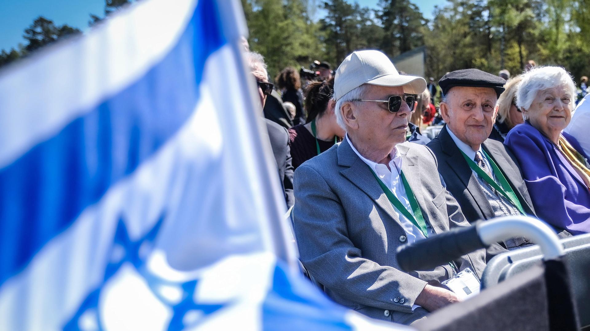 Im ehemaligen Konzentrationslager Bergen-Belsen versammeln sich hochbetagte Frauen und Männer, um der Befreiung im Frühjahr 1945 zu gedenken. Links ist die israelische Flagge mit dem Davidstern zu sehen. 