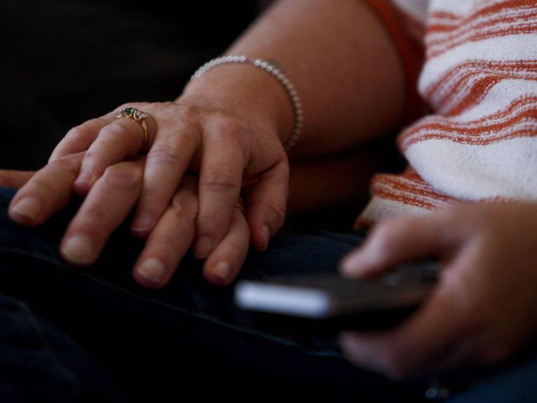 Die Hand einer Frau liegt auf der Hand eines Mannes