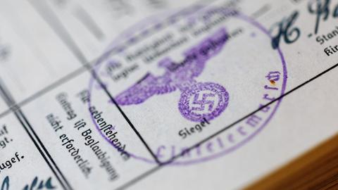 Ein Siegelstempel mit dem Parteiadler und Hakenkreuz ist in einem "Ahnenpass" aus dem Nationalsozialismus zu sehen.