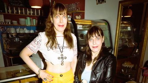 Kersty und Sandra Grether stehen in einem Laden vor einem Tresen.