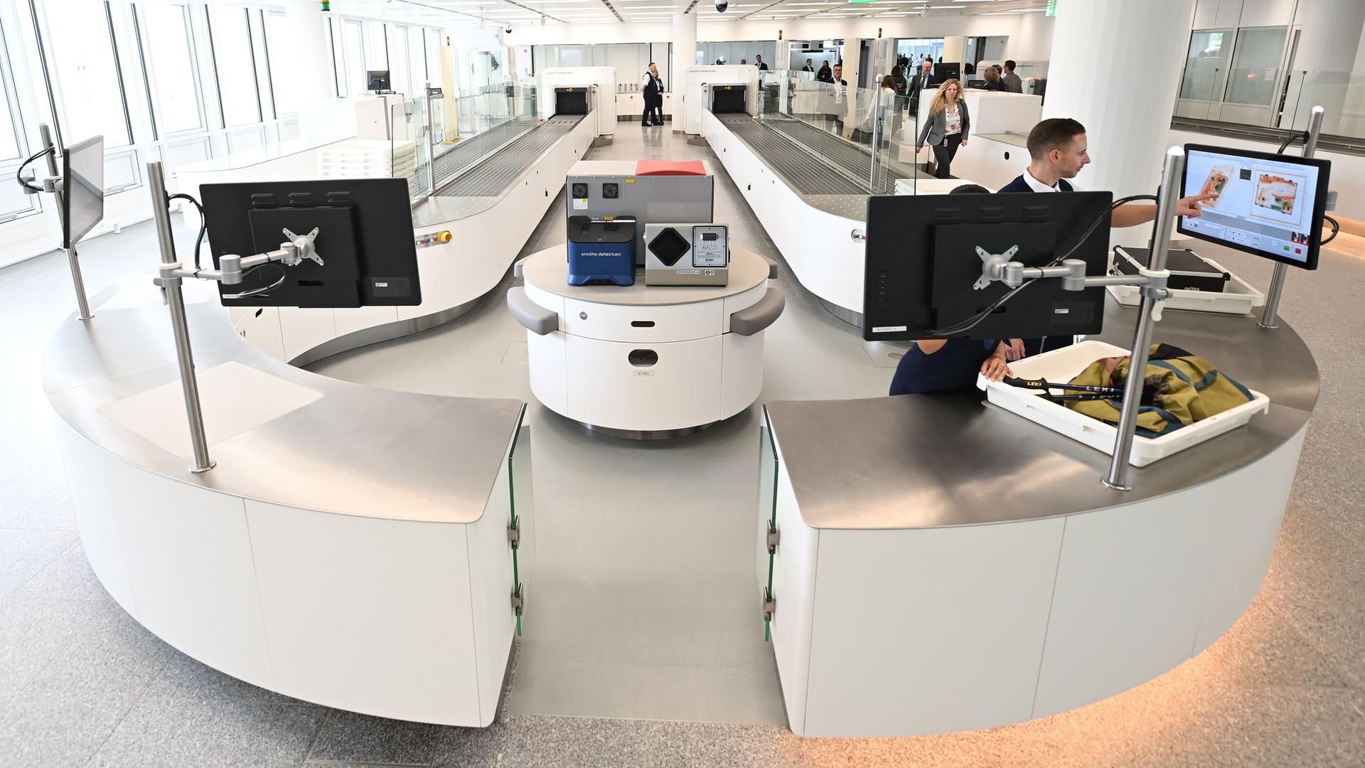 Zwei Mitarbeiter der Sicherheitskontrolle überprüfen in einer von insgesamt fünf neuen Anlagen am Flughafen München Gepäckstücke.