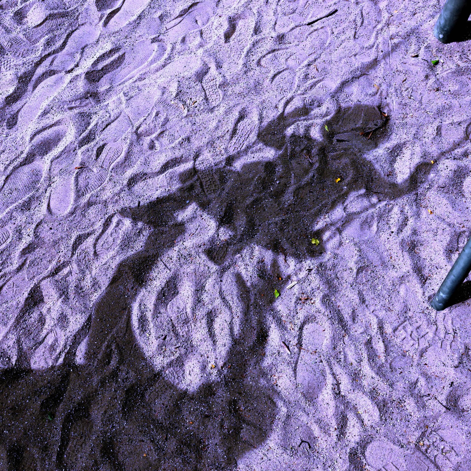 Das Foto zeigt den Schatten eines Kindes auf einer Schaukel. Davor der Schatten eines Erwachsenen, der die Arme nach dem Kind ausstreckt. 