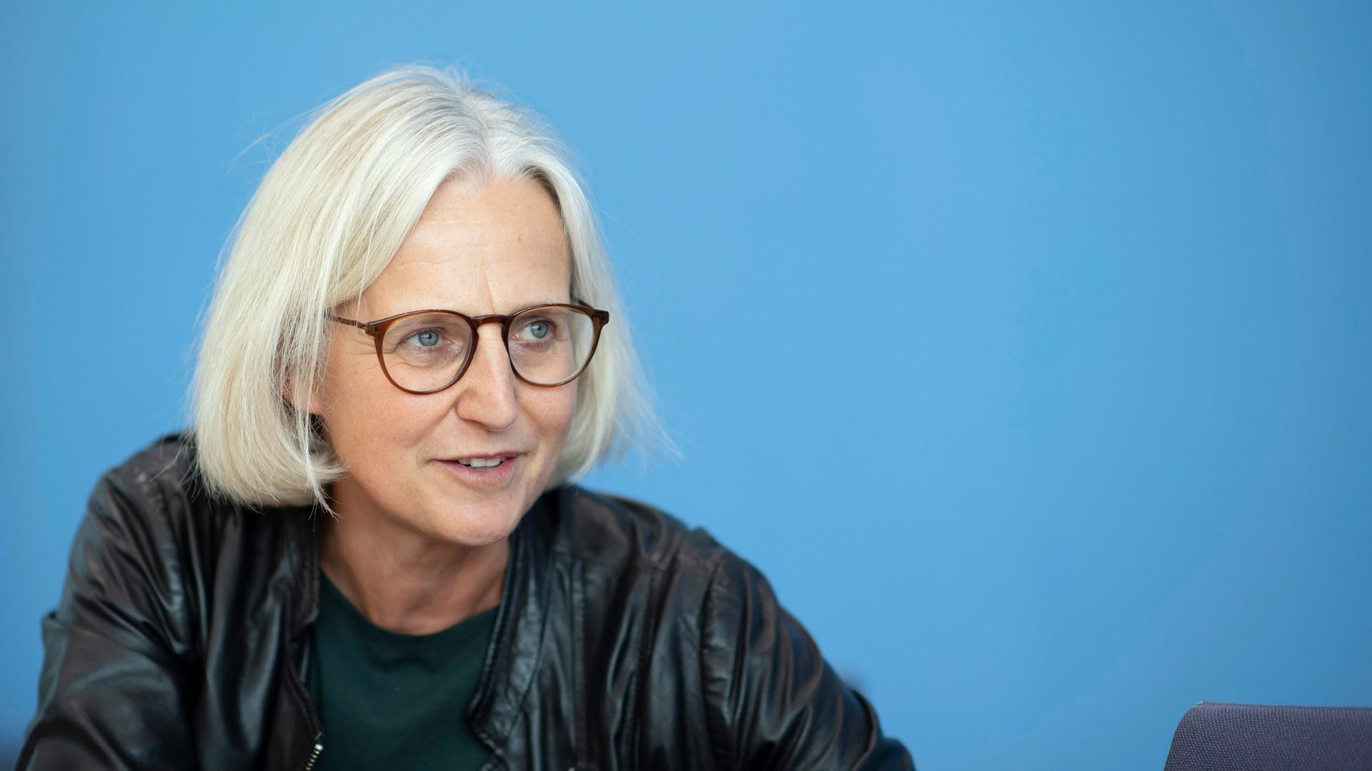 Die Autorin Christiane Hoffmann im Portrait von der Seite. Sie trägt eine Brille, hat blonde kurze Haare und trägt dunkle Kleidung. Die Autorin Christiane Hoffmann im Portrait von der Seite. Sie trägt eine Brille, hat blonde kurze Haare und trägt dunkle Kleidung.