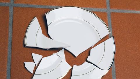 Ein zerbrochener Teller liegt auf einem Fuboden