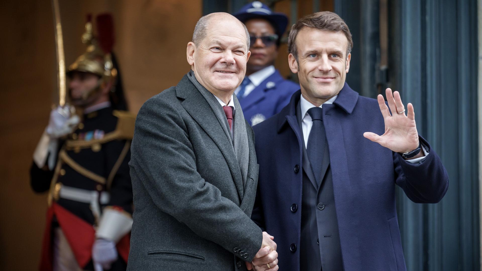 Bundeskanzler Olaf Scholz (SPD, l), steht neben Frankreichs Präsident Emmanuel Macron