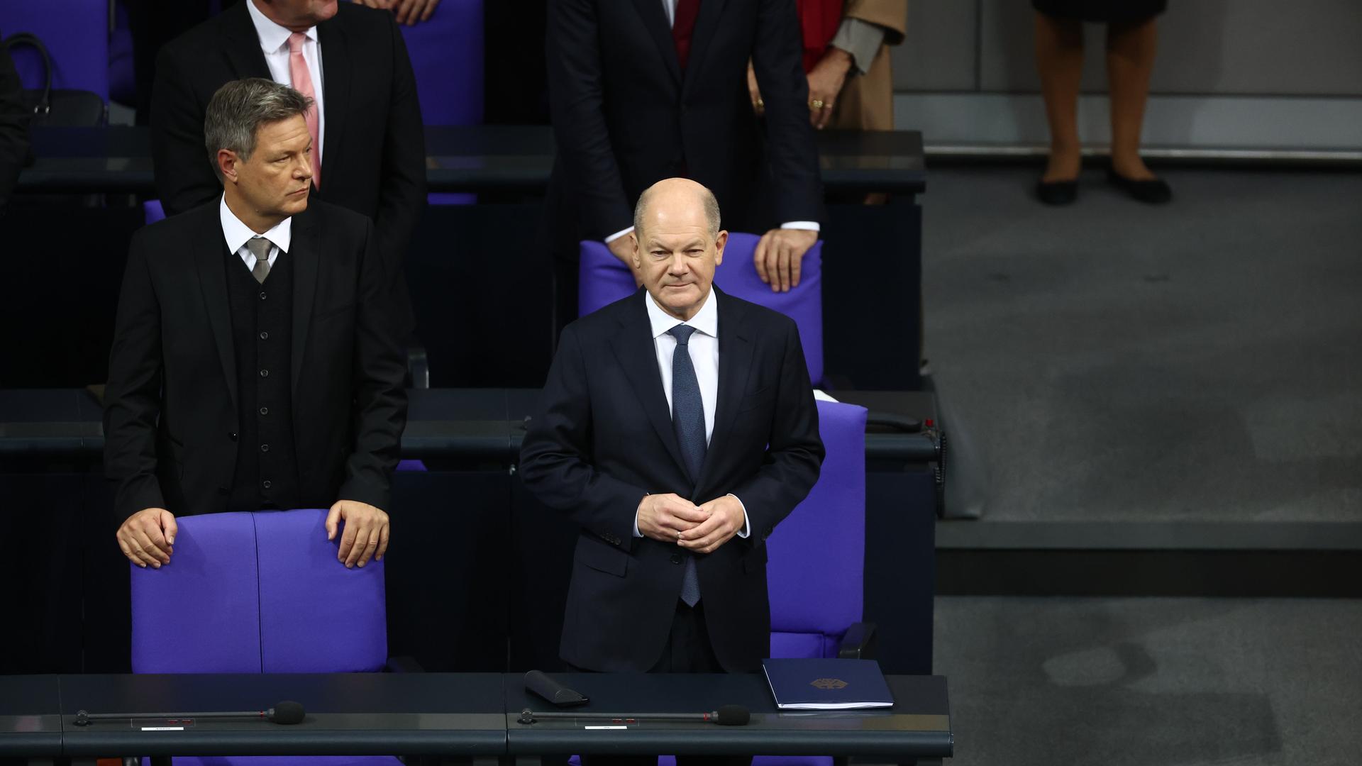 Bundeskanzler Olaf Scholz (SPD) steht neben Bundeswirtschaftsminister Robert Habeck (Bündnis 90/Die Grünen, l) an seinem Platz auf der Regierungsbank. 