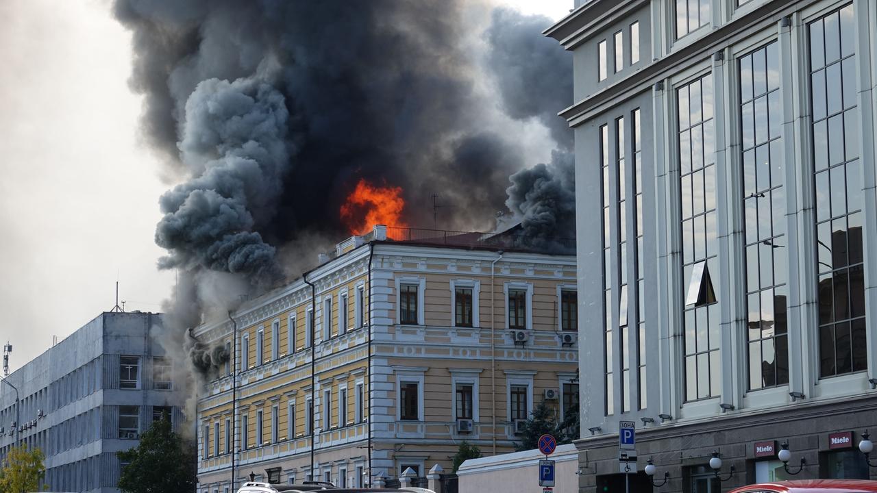 Feuer und Rauch steigen aus dem Dach des Gebäudes auf. 