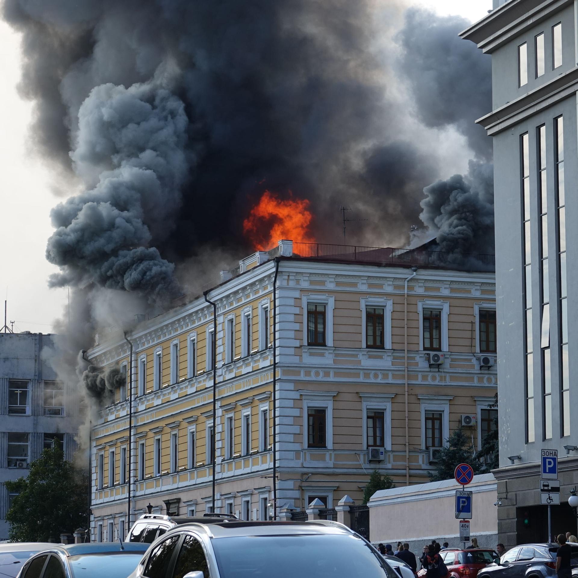 Feuer und Rauch steigen aus dem Dach des Gebäudes auf. 
