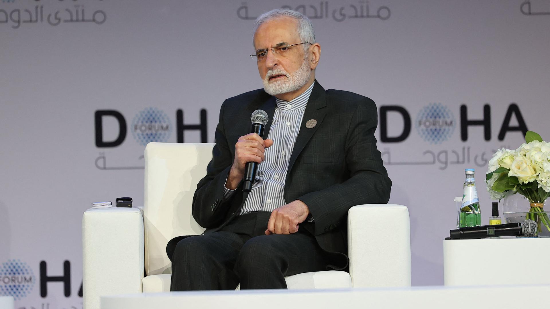Der ehemalige iranische Außenminister Sayyid Kamal Charrasi sitzt im März 2022 in Katar in einem Interview. Er hält ein Mikrofon in der rechten Hand.