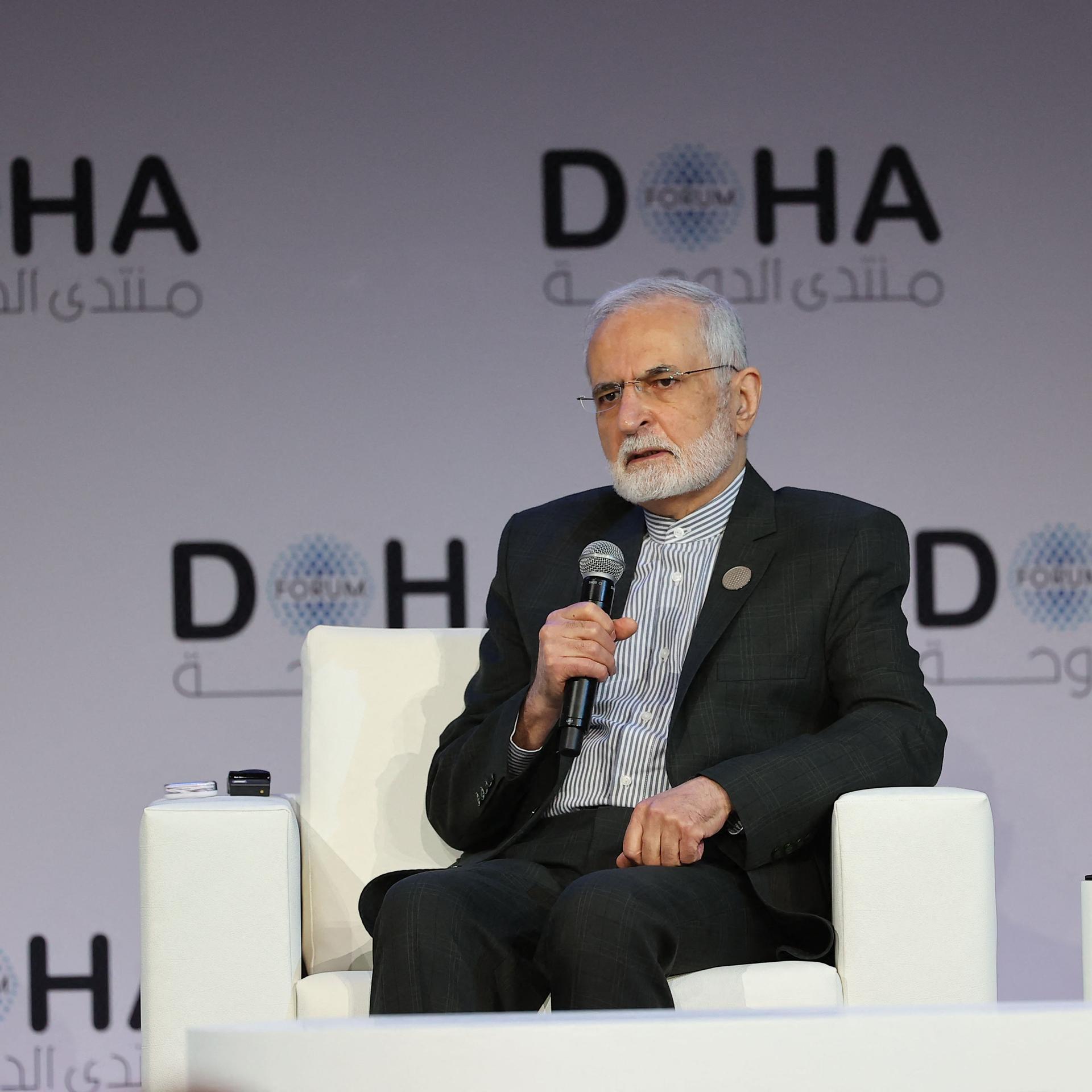 Der ehemalige iranische Außenminister Sayyid Kamal Charrasi sitzt im März 2022 in Katar in einem Interview. Er hält ein Mikrofon in der rechten Hand.