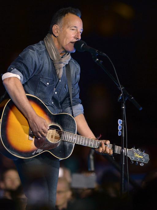 US-Rock-Musiker Bruce Springsteen steht auf einer Bühne und spielt Gitarre.
