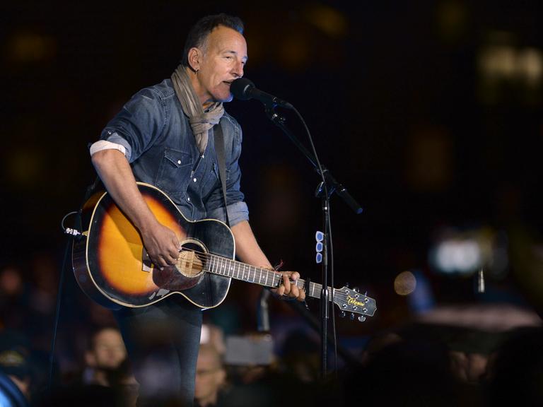 US-Rock-Musiker Bruce Springsteen steht auf einer Bühne und spielt Gitarre.