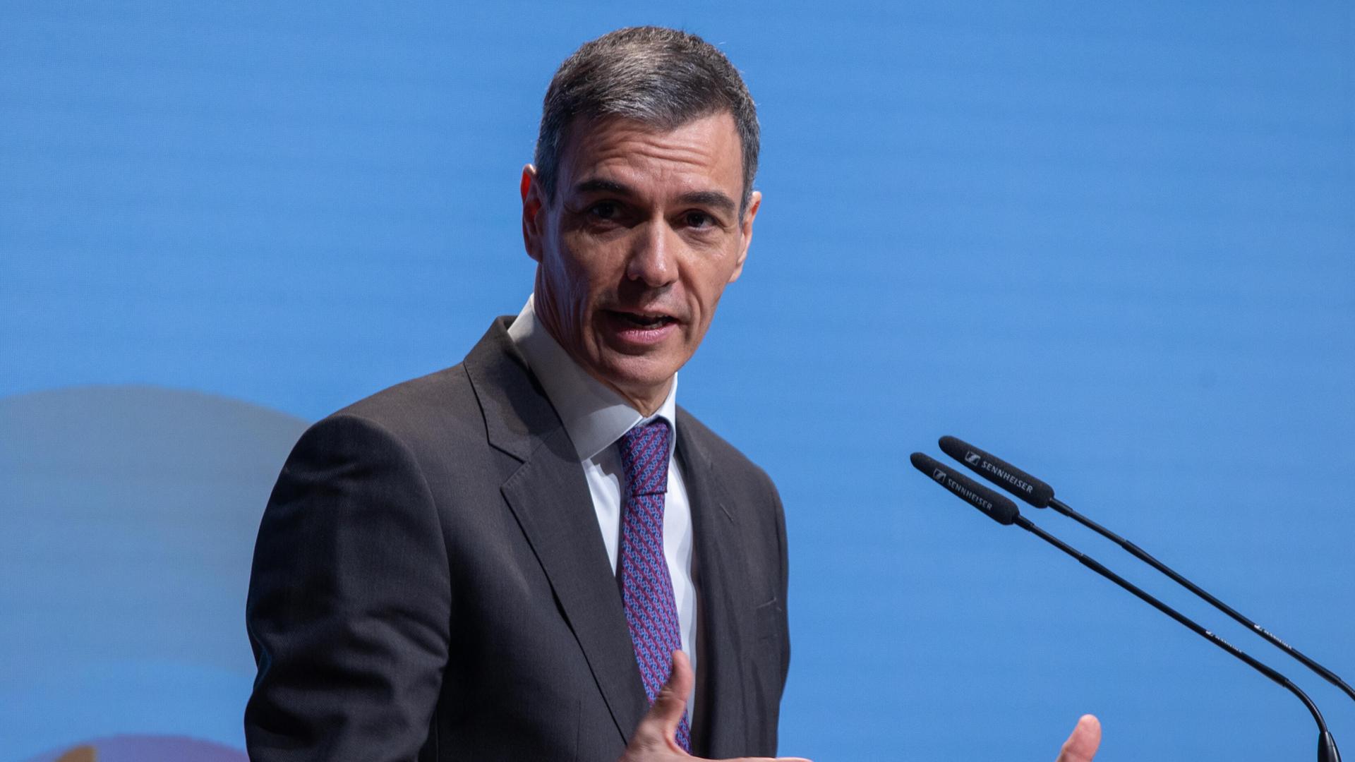 Der spanische Ministerpräsident Pedro Sanchez steht hinter einem Rednerpult. Der spanische Ministerpräsident Pedro Sanchez steht hinter einem Rednerpult.