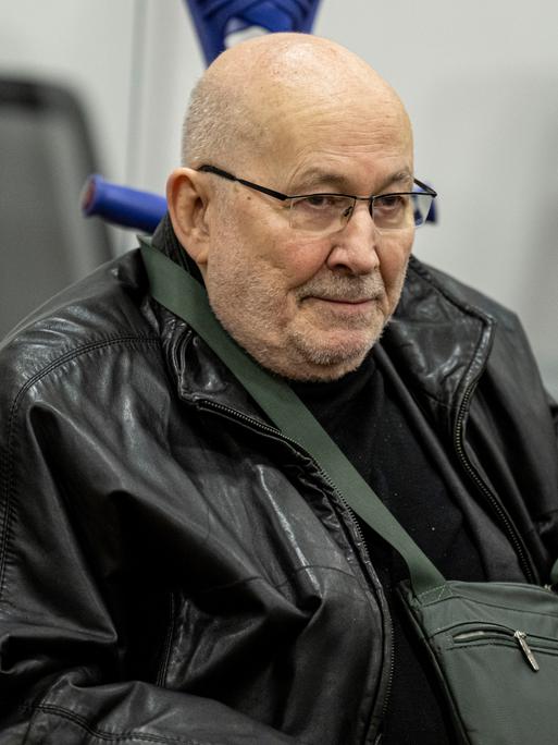 Horst Mahler im Alter von 86 Jahren vor Gericht in Potsdam. Er ist kahlhäuptig, trägt eine Brille und sitzt im Rollstuhl.