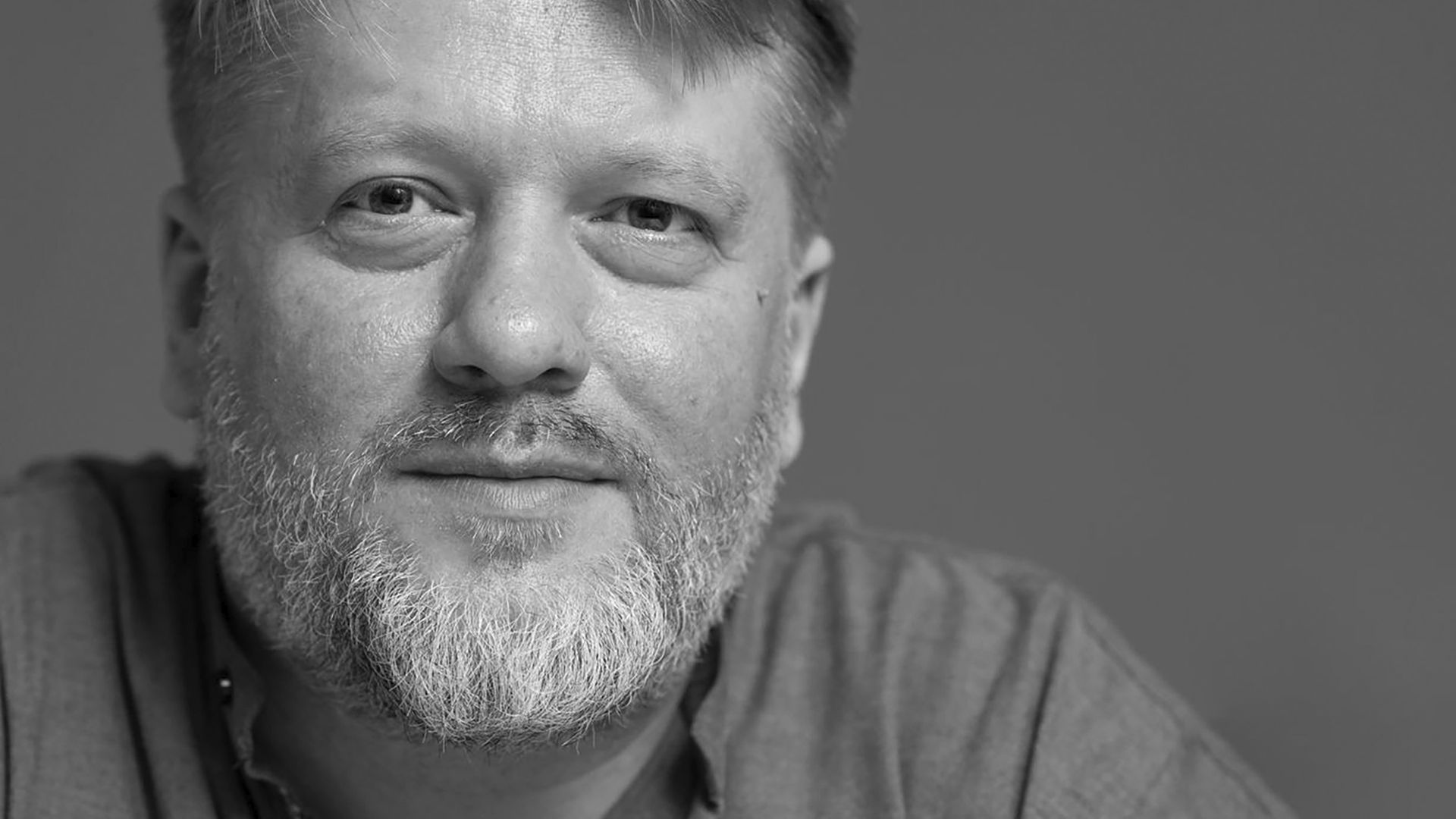 Schwarz-Weiß Portrait von Georg Genoux, der freundlich in die Kamera schaut Schwarz-Weiß Portrait von Georg Genoux, der freundlich in die Kamera schaut