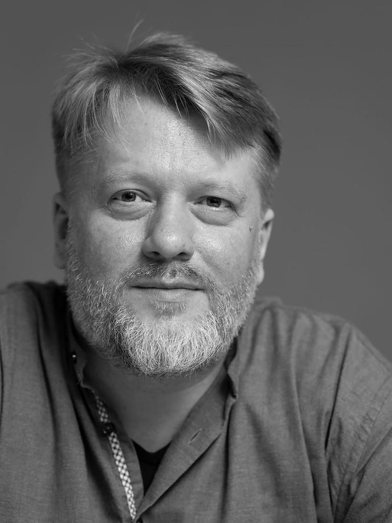 Schwarz-Weiß Portrait von Georg Genoux, der freundlich in die Kamera schaut