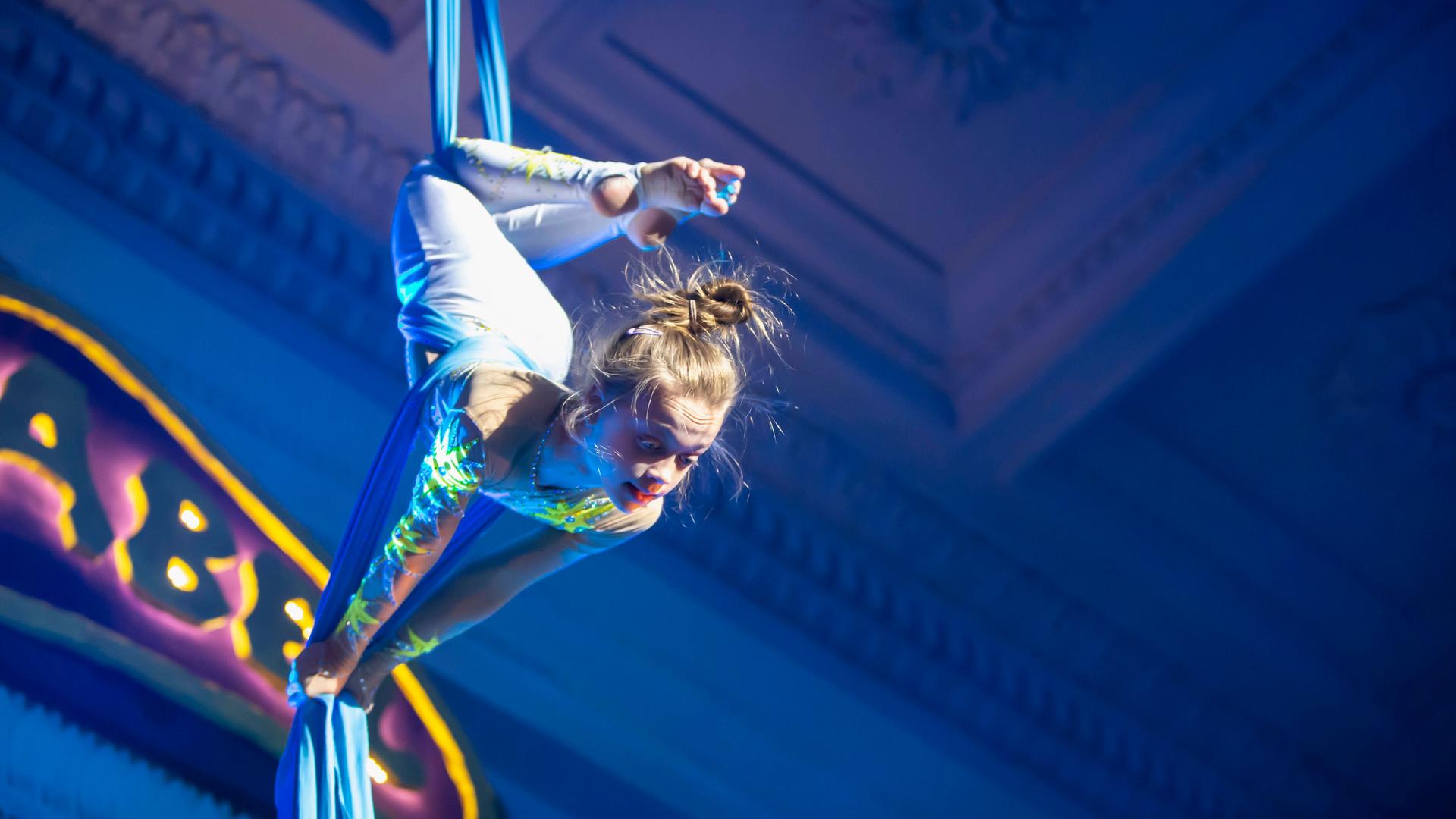 Ein Mädchen tritt mit einer Akrobatiknummer im Zirkus auf.