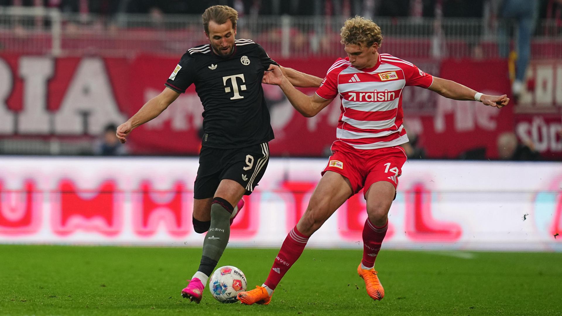Bayerns Fußballprofi Harry Kane in einem Zweikampf mit Leopold Querfeld von Union Berlin. Bayerns Fußballprofi Harry Kane in einem Zweikampf mit Leopold Querfeld von Union Berlin.