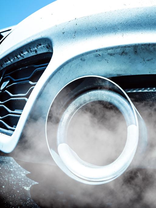 Qualmende Auspuffrohre eines Autos mit Verbrennermotor Qualmende Auspuffrohre eines Autos mit Verbrennermotor