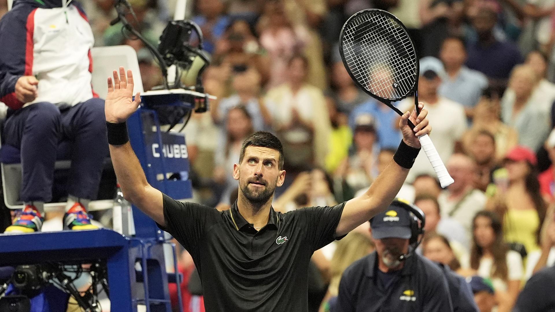 Der Tennisspieler Novak Djokovic hebt beide Arme und jubelt nach seinem Sieg bei den US Open. 