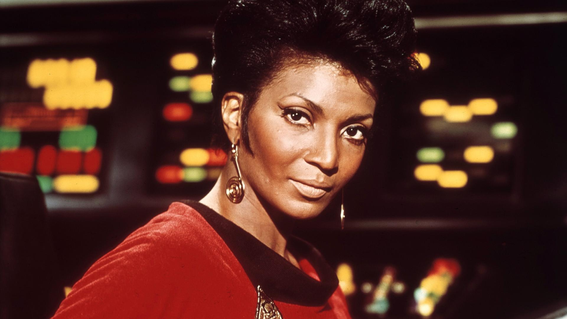 Die schwarze Schauspielerin Nichelle Nichols trägt in Star Trek als Kommunikationsoffizier Lieutenant Uhura eine rote Uniform. Die schwarze Schauspielerin Nichelle Nichols trägt in Star Trek als Kommunikationsoffizier Lieutenant Uhura eine rote Uniform.