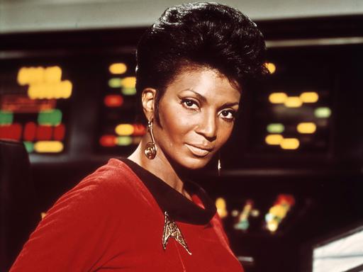 Die schwarze Schauspielerin Nichelle Nichols trägt in Star Trek als Kommunikationsoffizier Lieutenant Uhura eine rote Uniform. Die schwarze Schauspielerin Nichelle Nichols trägt in Star Trek als Kommunikationsoffizier Lieutenant Uhura eine rote Uniform.
