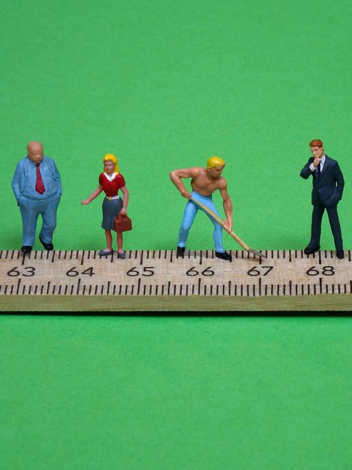 Figuren auf einem Zollstock. Ihr Standort markiert das jeweilige Rentenalter.
