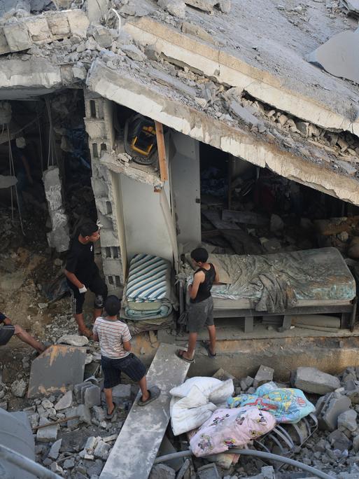 Palästinenser untersuchen ein Haus in Gaza-City, das bei einem israelischen Luftangriff schwer beschädigt wurde.