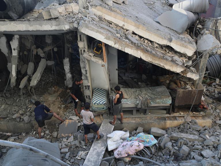 Palästinenser untersuchen ein Haus in Gaza-City, das bei einem israelischen Luftangriff schwer beschädigt wurde.