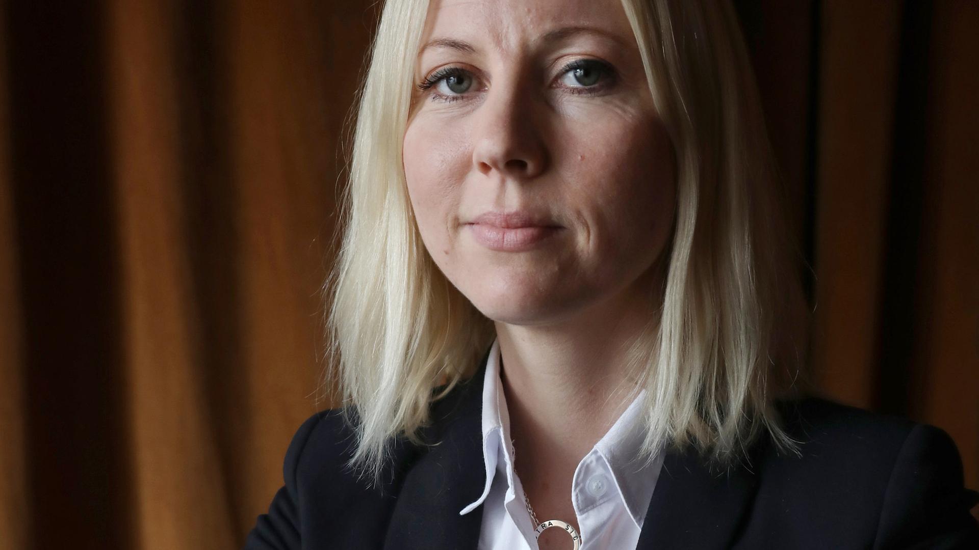 Die finnische Journalistin Jessikka Aro sitzt selbstbewusst auf einem umgedrehten Stuhl, 2019.
