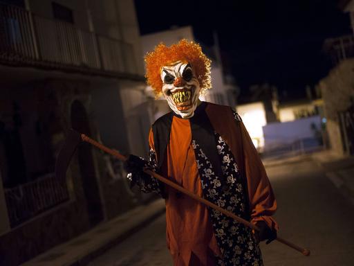 Ein als teuflischer Clown verkleideter Mann.