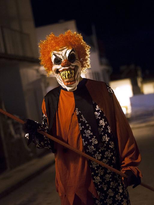Ein als teuflischer Clown verkleideter Mann. Ein als teuflischer Clown verkleideter Mann.