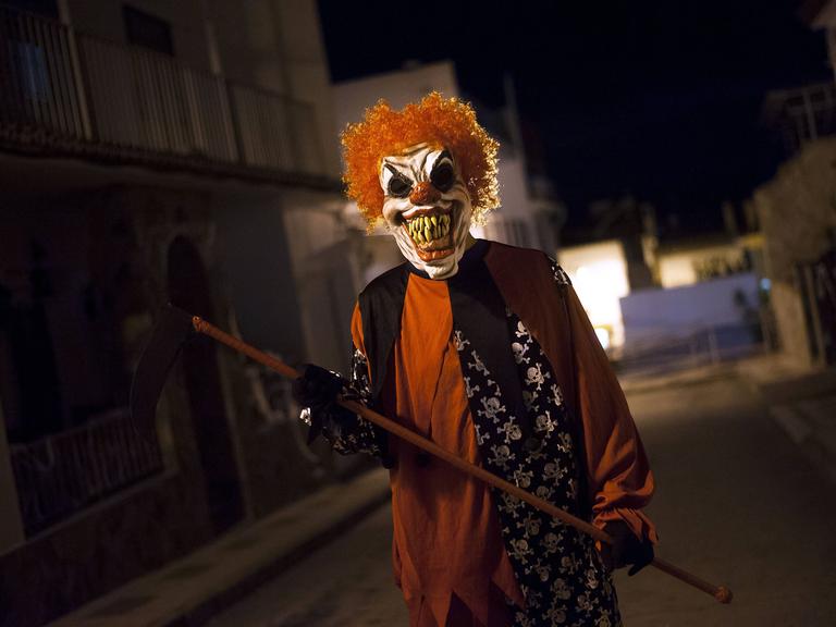 Ein als teuflischer Clown verkleideter Mann. Ein als teuflischer Clown verkleideter Mann.