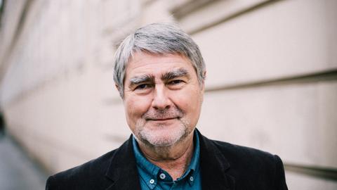 Portrait von Kurt Kotrschal mit einer Hauswand im Hintergrund