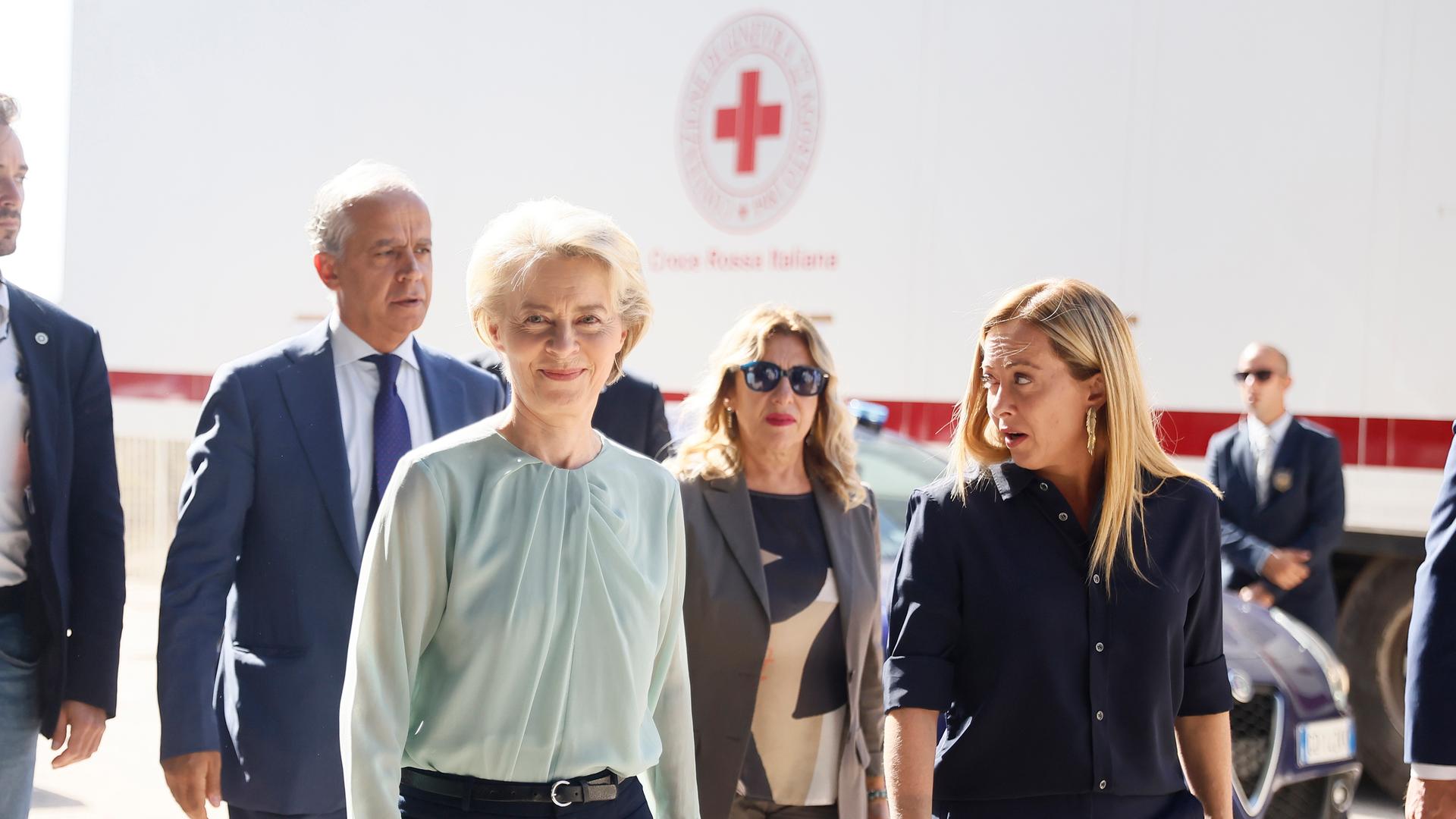 Die Präsidentin der Europäischen Kommission, von der Leyen, lächelt bei einem Besuch der Insel Lampedusa in die Kamera, rechts von ihr steht Italiens Ministerpräsidentin Meloni.