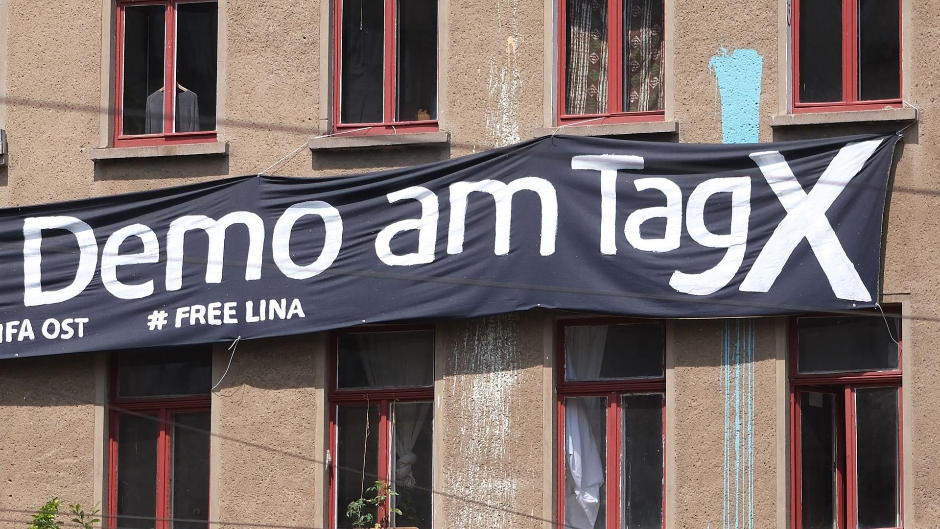 Ein Transparent mit der Aufschrift "Demo am Tag X" und "# Free Lina" hängt an der Fassade eines Hauses in Leipzig
