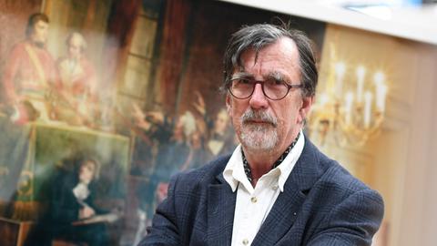 Der Wissenschaftssoziologe und Philosoph Bruno Latour steht vor einem Gemälde und blickt in die Kamera