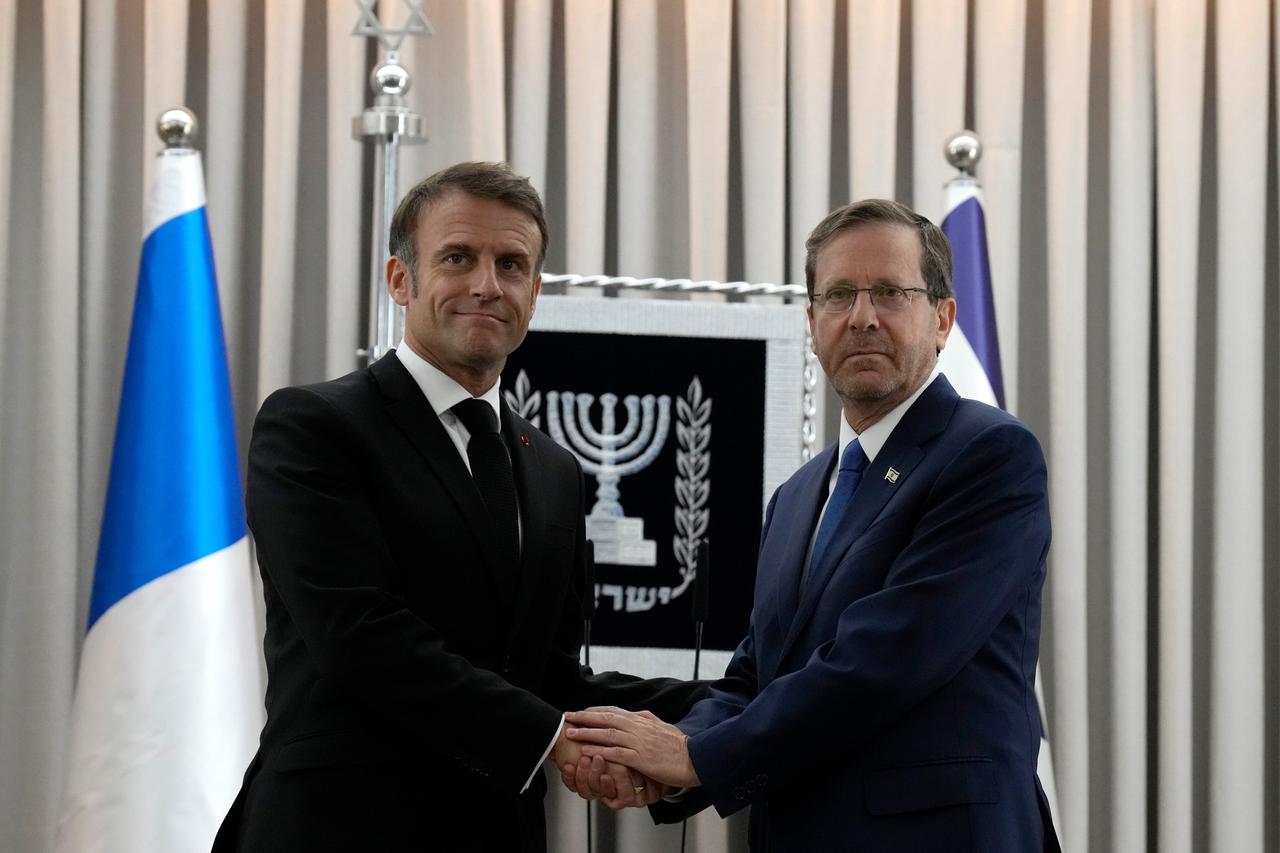 Israel, Jerusalem: Der französische Präsident Emmanuel Macron,  links, und Israels Präsident Isaac Herzog schütteln sich die Hände. 