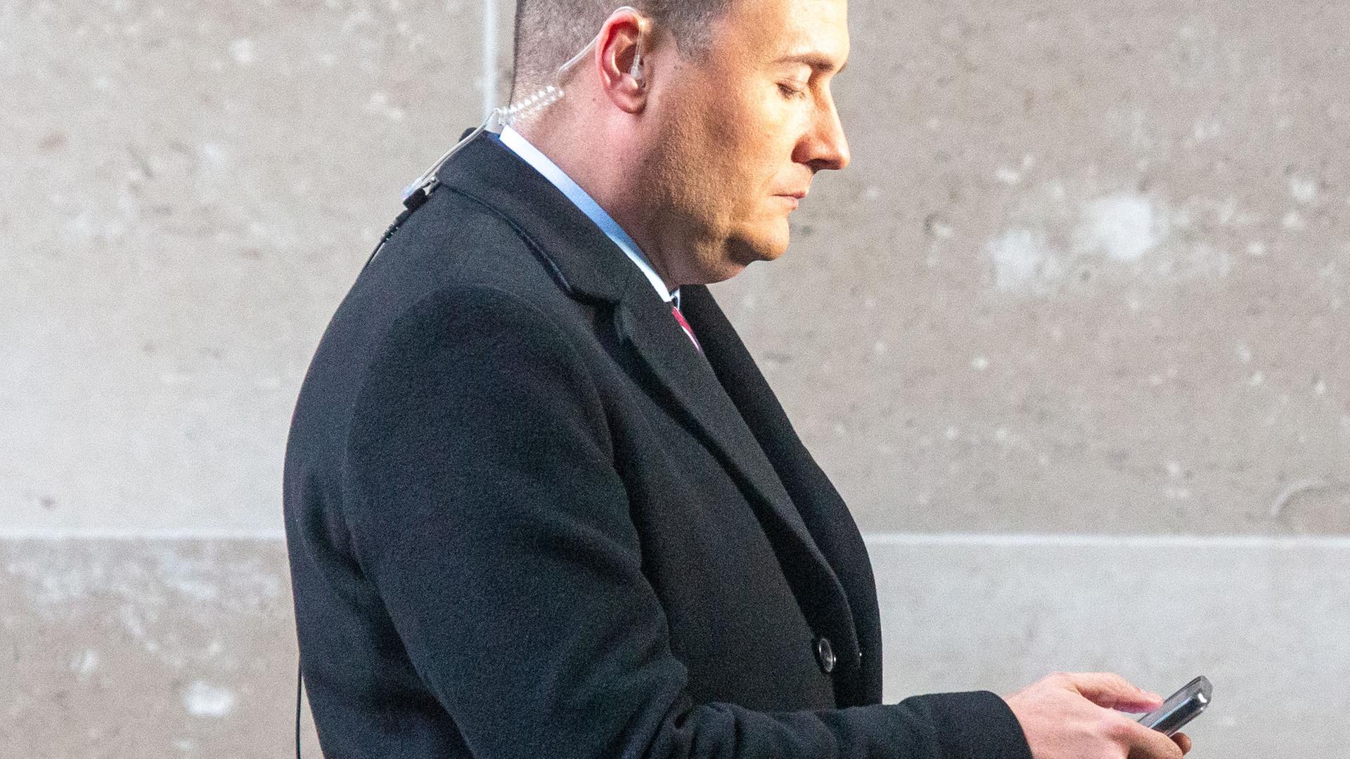Gesundheitsminister Großbritanniens Wes Streetings im Profil mit Blick auf sein Mobiltelefon. Gesundheitsminister Großbritanniens Wes Streetings im Profil mit Blick auf sein Mobiltelefon.