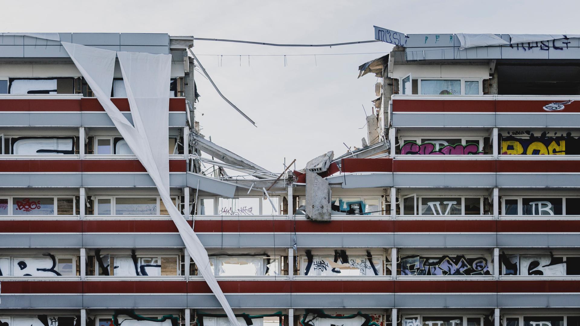 Baukräne reißen in Berlin eine Gebäude ein.